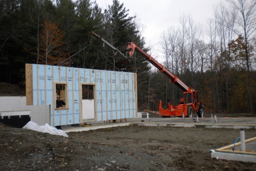 An allied contractor red crane installs a wall section during a new home installation in central vermont