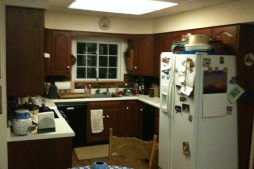 cluttered barre kitchen with white coutertops and appliances before kitchen remodeling project by allied contractors