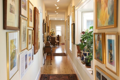New home build hallway with framed photos and area rugs in central vermont project by allied builders