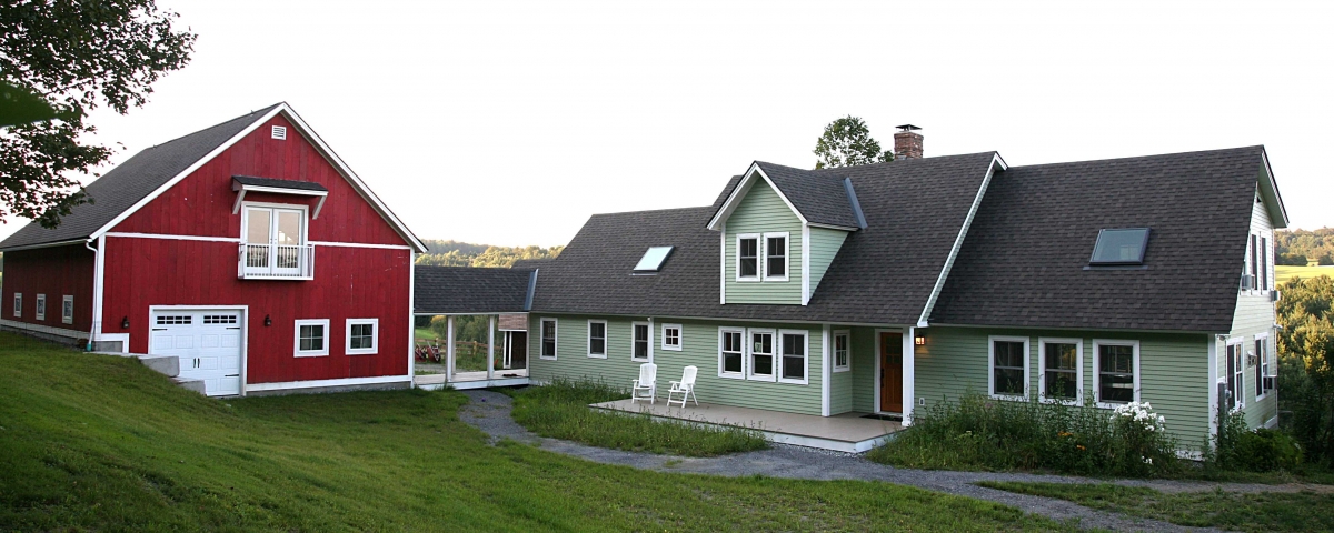 Green house and red garage in central vermont after completion of home remodeling project