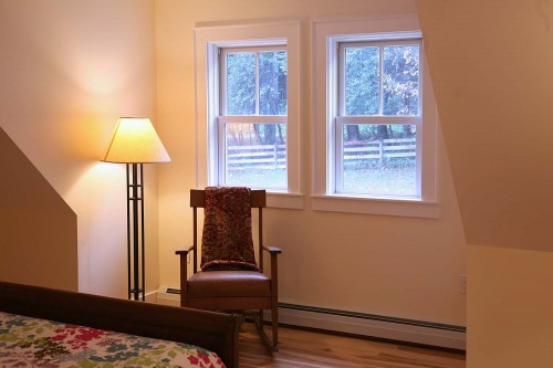 lamp and red chair under new green windows in new central vermont home project by allied builders