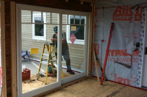 An allied building contractor installs a large glass door during new build project