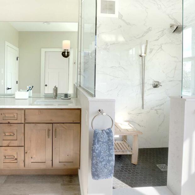 bathroom with wooden cabinets and large glass shower