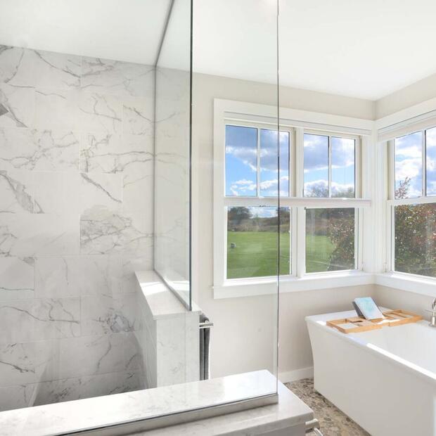 bathroom with large shower and tub featuring windows looking out onto nature