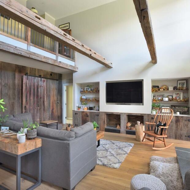 living room with grey couch, rocking chair and bookshelves