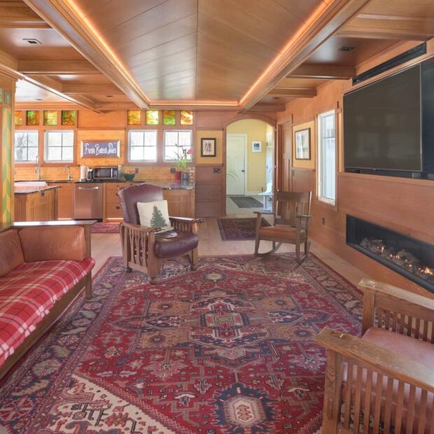 living room featuring red patterned area rug and wood seating