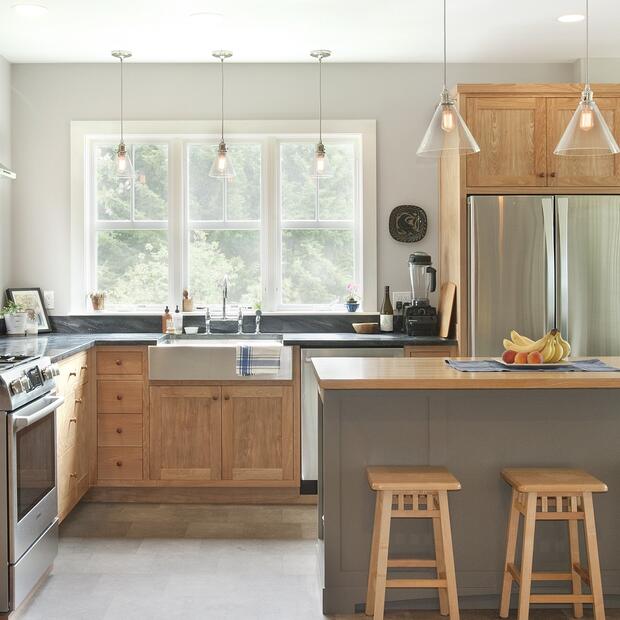 spacious kitchen with a farmhouse sink, wood island, and stainless steel appliances