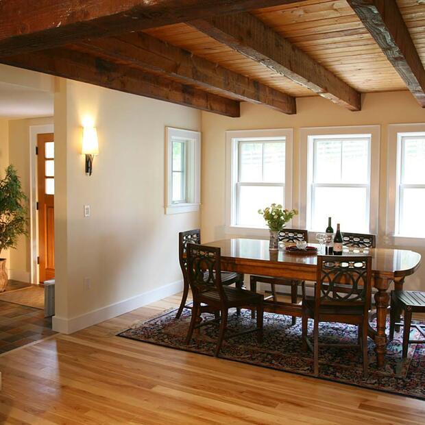 farmhouse dining space with a wooden table, area rug, and warm lighting