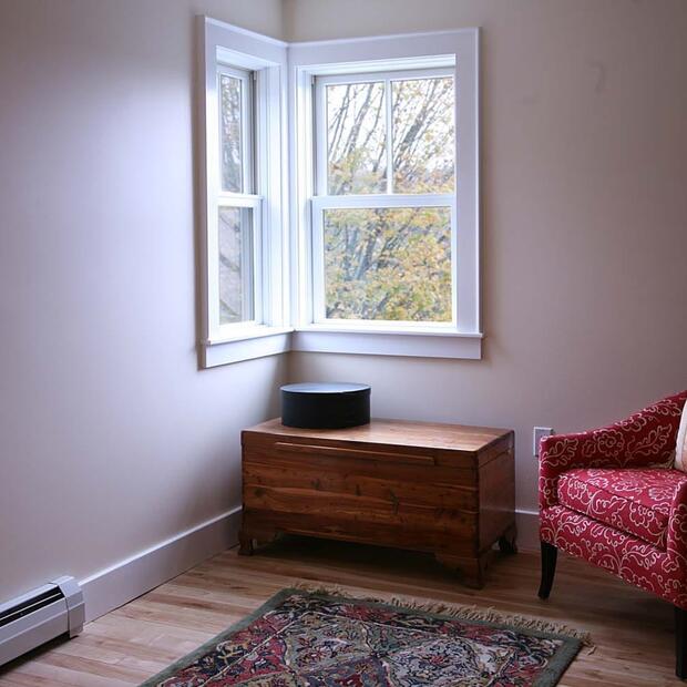 simple and cozy sitting area with a red armchair and wooden chest