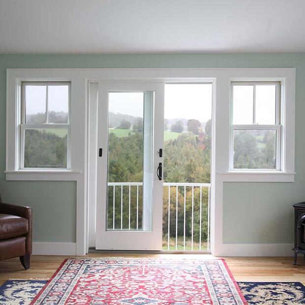 primary bedroom with red patterned area rug and views of nature