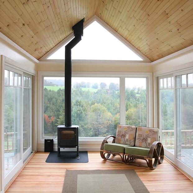 sunroom with a wood ceiling, woodstove, and scenic countryside views