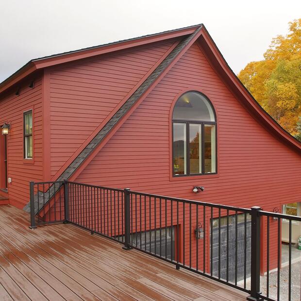 red farmhouse with wood deck