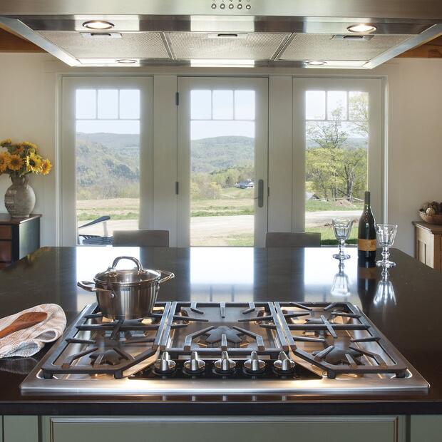 kitchen with a central gas stove, large windows, and a bright outdoor landscape