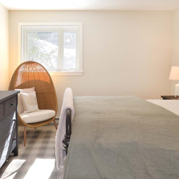 bedroom featuring a wooden bed, dark dresser, and a stylish egg chair