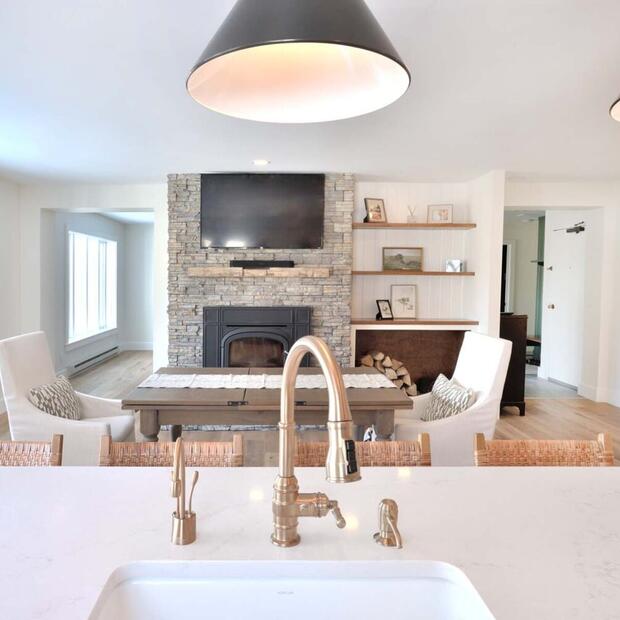 Open-concept kitchen and dining space with a cozy fireplace and shelves