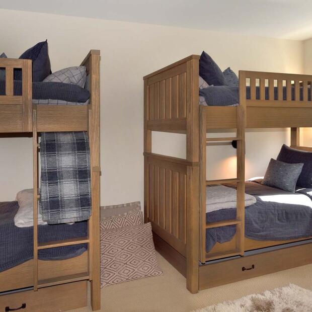 bedroom with two wooden bunk beds and navy blue bedding