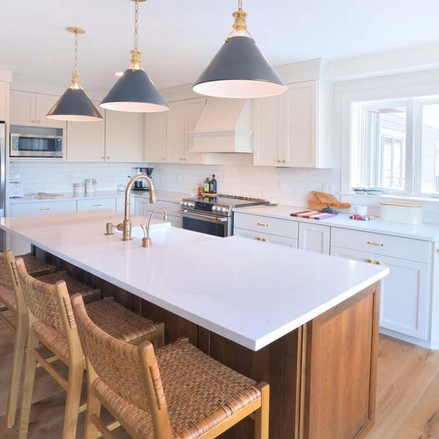 farmhouse kitchen featuring white cabinetry, brass accents, and wood flooring