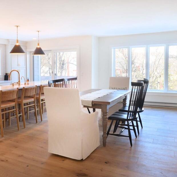 open-concept kitchen and dining area with a stone fireplace and large windows