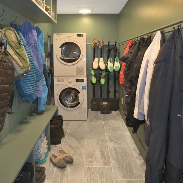 mudroom featuring ski gear, jackets, and a laundry station