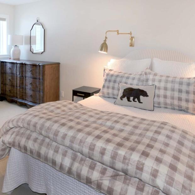 farmhouse-style bedroom with a tufted headboard and vintage dresser